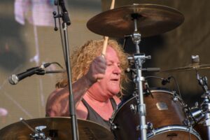 Brian Gillstrom performing on drums during a live rock concert.