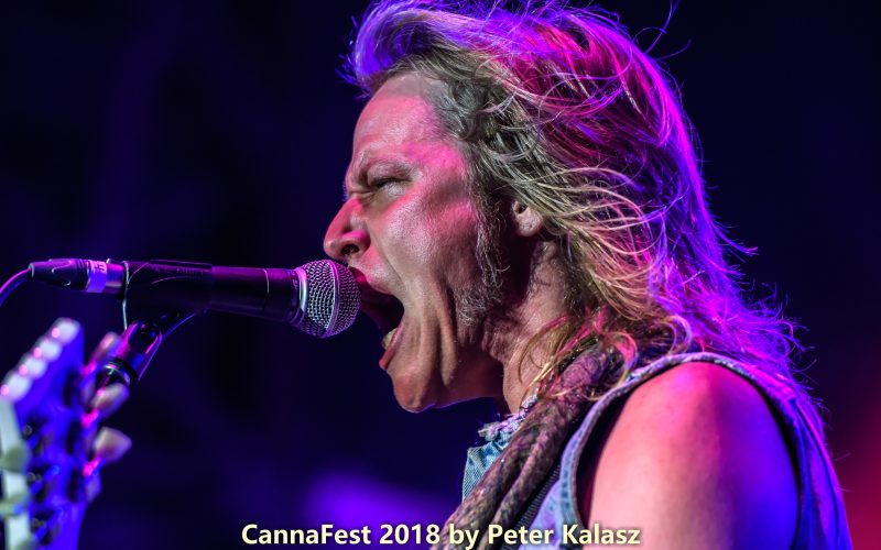 Jeremy Asbrock singing into a microphone during a live rock performance.